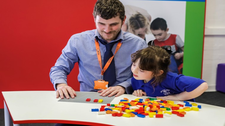 Volwassene en kind spelen met Braille Bricks