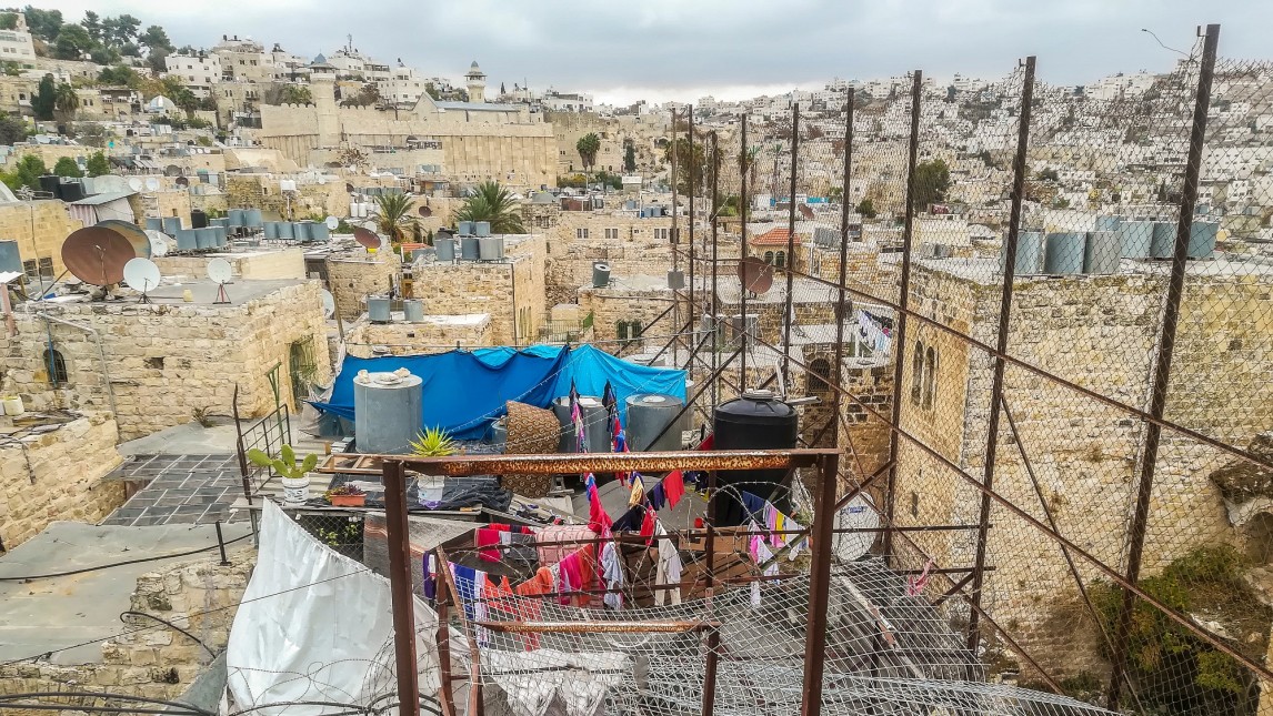 De daken van huizen van Joodse kolonisten en Palestijnse inwoners van de stad Hebron