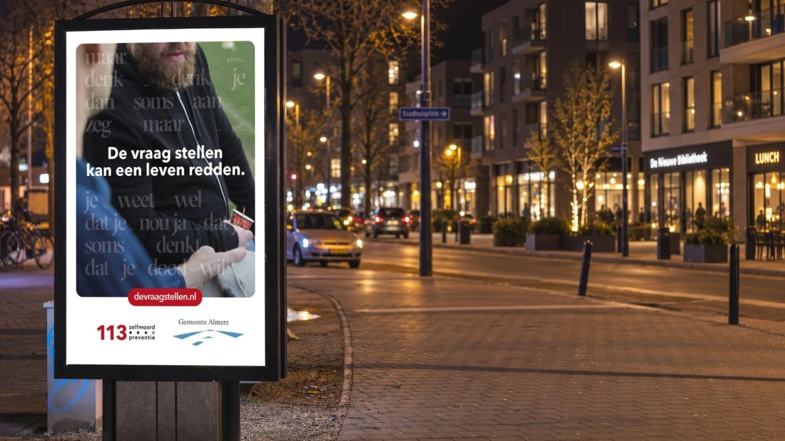 Een abri met een campagneposter van 113 