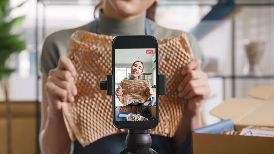 Een vrouw toont een product dat zij kan verkopen via TikTok Shop