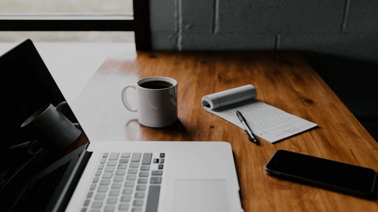 Laptop met papier en koffie