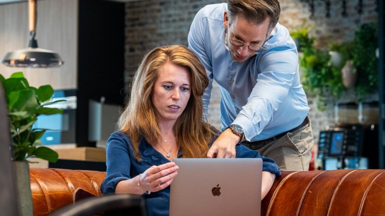 Afbeelding van jonge vrouw achter een laptop. Op de afbeelding staat: Enter the world of media.