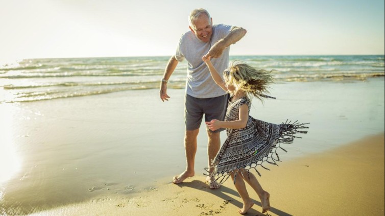 Opa en kleinkind op het strand